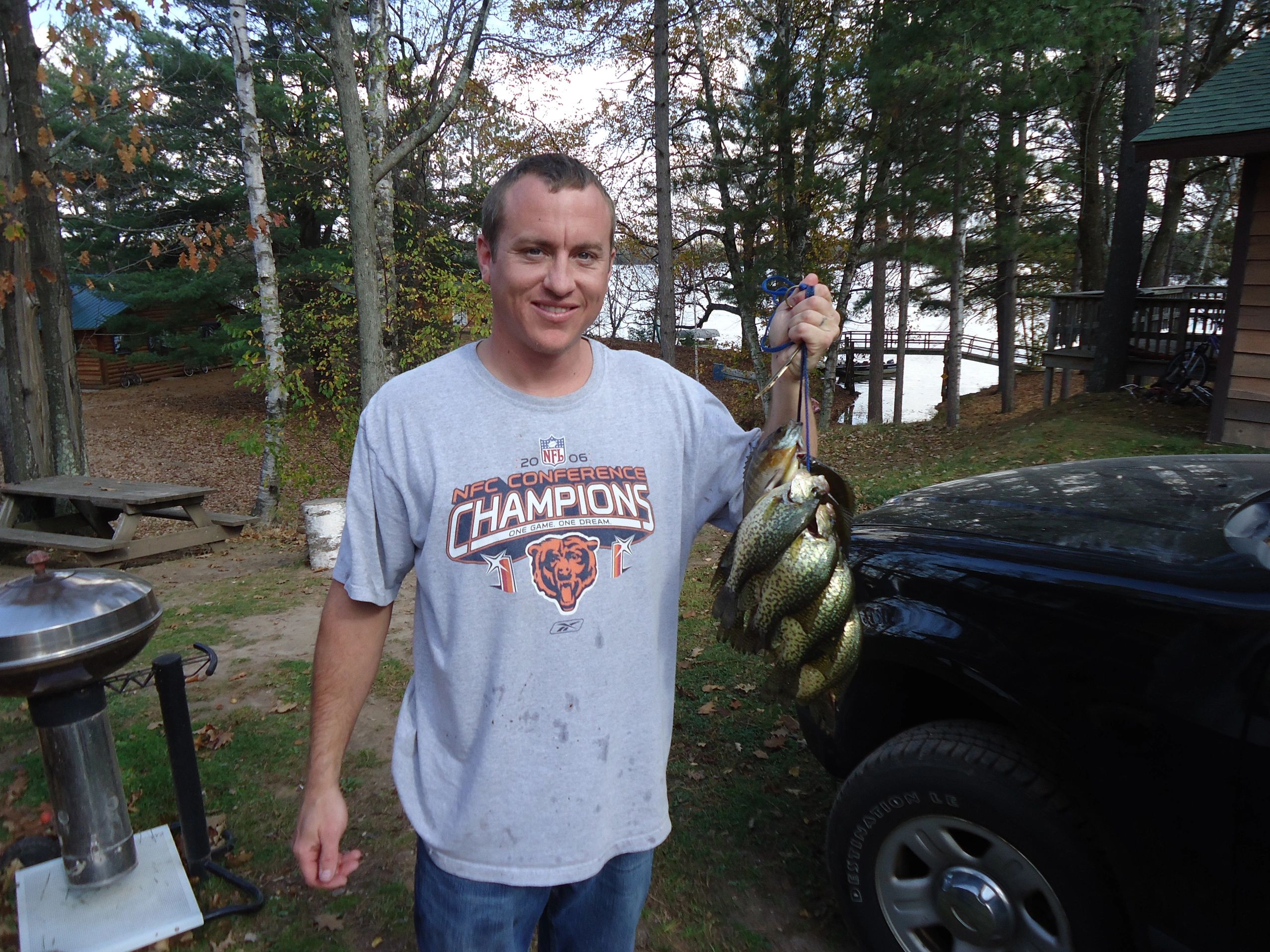 Man with a stringer of fish at the cabin